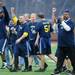 THe blue team celebrates winning the Victors Classic alumni football game at Michigan Stadium on Saturday. Melanie Maxwell I AnnArbor.com